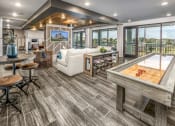 Thumbnail 12 of 48 - A game room with a shuffle board and seating
