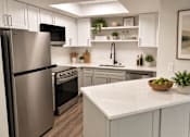 Thumbnail 11 of 20 - A modern kitchen with a stainless steel refrigerator and a marble countertop.