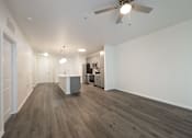 Thumbnail 22 of 35 - A spacious room with a ceiling fan and a kitchenette in the background.