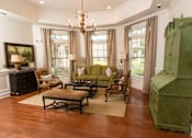 Thumbnail 5 of 18 - A living room with a green sofa and a wooden coffee table.