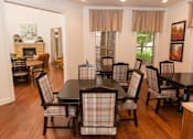 Thumbnail 9 of 18 - A dining room with a black table and chairs.
