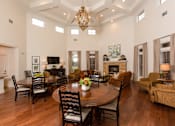Thumbnail 3 of 18 - A large dining room with a wooden table surrounded by chairs.