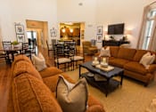 Thumbnail 8 of 18 - A living room with a brown couch and a coffee table.