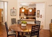 Thumbnail 4 of 18 - A dining room with a table and chairs.
