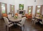 Thumbnail 3 of 23 - A living room with a fireplace and a dining table.