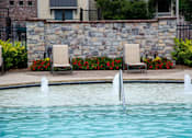 Thumbnail 14 of 23 - A pool with a stone wall and fountains in the middle.