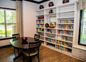 Thumbnail 8 of 23 - A room with a table, chairs and a bookshelf.