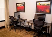 Thumbnail 6 of 23 - Two computers on desks in a room with two chairs.
