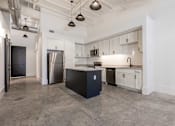 Thumbnail 15 of 33 - A kitchen with a black island in the middle of the room.