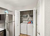 Thumbnail 10 of 13 - A small laundry room with a washer and dryer.