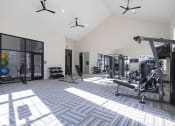 Thumbnail 8 of 21 - a gym with weights and other equipment in a building with windows