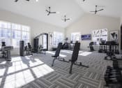 Thumbnail 9 of 21 - a spacious fitness room with weights and cardio machines and windows