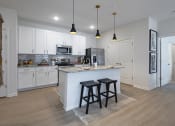 Thumbnail 12 of 21 - a kitchen with white cabinets and a large island with two stools