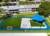 Thumbnail 27 of 31 - a blue tent is set up on a tennis court in front of a row of houses  at Waterview at Rocky Point, Tampa