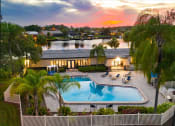 Thumbnail 2 of 31 - an aerial view of a resort style swimming pool with palm trees and a building in the background at Waterview at Rocky Point, Tampa Florida
