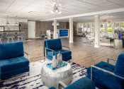 Thumbnail 5 of 31 - a lobby with blue chairs and a table with vases on top of it at Waterview at Rocky Point, Tampa, 33634