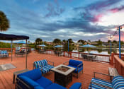Thumbnail 26 of 31 - a deck with blue couches and chairs overlooking a body of water at Waterview at Rocky Point, Tampa, FL