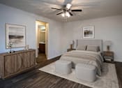 Thumbnail 6 of 24 - A bedroom with a bed, nightstands, and a ceiling fan.