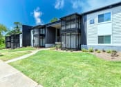 Thumbnail 1 of 13 - a group of houses in a row with a grassy area and trees in the background