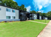 Thumbnail 12 of 13 - a row of apartment buildings with a green lawn in front of them