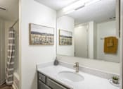 Thumbnail 19 of 36 - A bathroom with a white sink and a mirror.