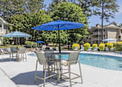 Thumbnail 22 of 36 - A blue umbrella is in front of a pool.