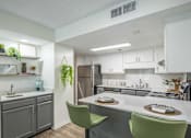 Thumbnail 8 of 36 - A kitchen with a white countertop and green chairs.