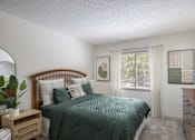 Thumbnail 13 of 36 - A bedroom with a bed, nightstand, and window.