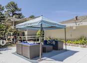 Thumbnail 25 of 36 - A patio with a blue canopy and a white fence.
