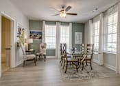 Thumbnail 8 of 14 - A dining room with a table and chairs.