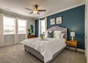 Thumbnail 9 of 14 - A bedroom with a large bed and a ceiling fan.