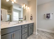 Thumbnail 10 of 14 - A bathroom with a vanity and a mirror.