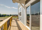 Thumbnail 13 of 14 - A balcony with a bench and a view of the sky.