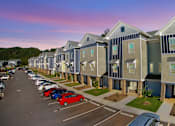Thumbnail 1 of 34 - A long row of houses with cars parked in front.