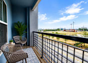 Thumbnail 16 of 29 - A balcony with two chairs and a table.