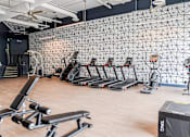 Thumbnail 21 of 29 - A gym with a variety of equipment including treadmills, weights, and a box labeled "TAG".