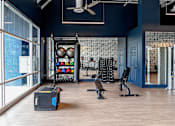 Thumbnail 20 of 29 - A gym with a variety of equipment including a squat rack, bench, and weights.