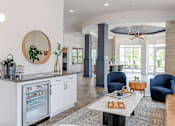 Thumbnail 17 of 29 - A modern kitchen with a white fridge and a round mirror on the wall.
