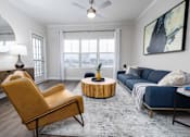Thumbnail 8 of 29 - A living room with a yellow chair and a blue couch.