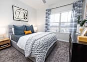 Thumbnail 11 of 29 - A bedroom with a large bed and a ceiling fan.
