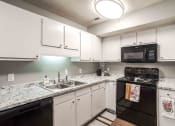 Thumbnail 5 of 30 - a kitchen with granite counter tops and black appliances