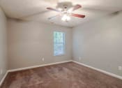 Thumbnail 9 of 30 - an empty living room with a ceiling fan and a window