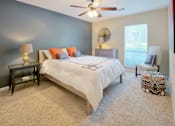 Thumbnail 27 of 32 - Columbus Luxury Apartments For Rent - Spacious Bedroom With Ceiling Fan, Carpet Flooring, And A Large Window With Blinds.