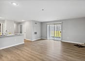 Thumbnail 8 of 13 - A spacious room with wooden flooring and white walls.