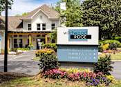 Thumbnail 30 of 30 - A sign for Wildwood Ridge Premier Apartment Homes is in front of a building.