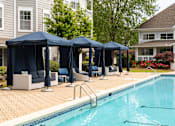 Thumbnail 23 of 30 - A pool with a blue canopy and chairs around it.