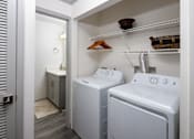 Thumbnail 11 of 30 - A small bathroom with a washer and dryer.