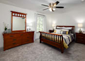 Thumbnail 9 of 30 - A bedroom with a bed, dresser, and mirror.