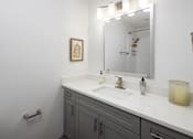 Thumbnail 10 of 30 - A bathroom with a white sink and a mirror above it.