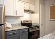 Thumbnail 4 of 23 - A kitchen with a refrigerator, oven, and cabinets.